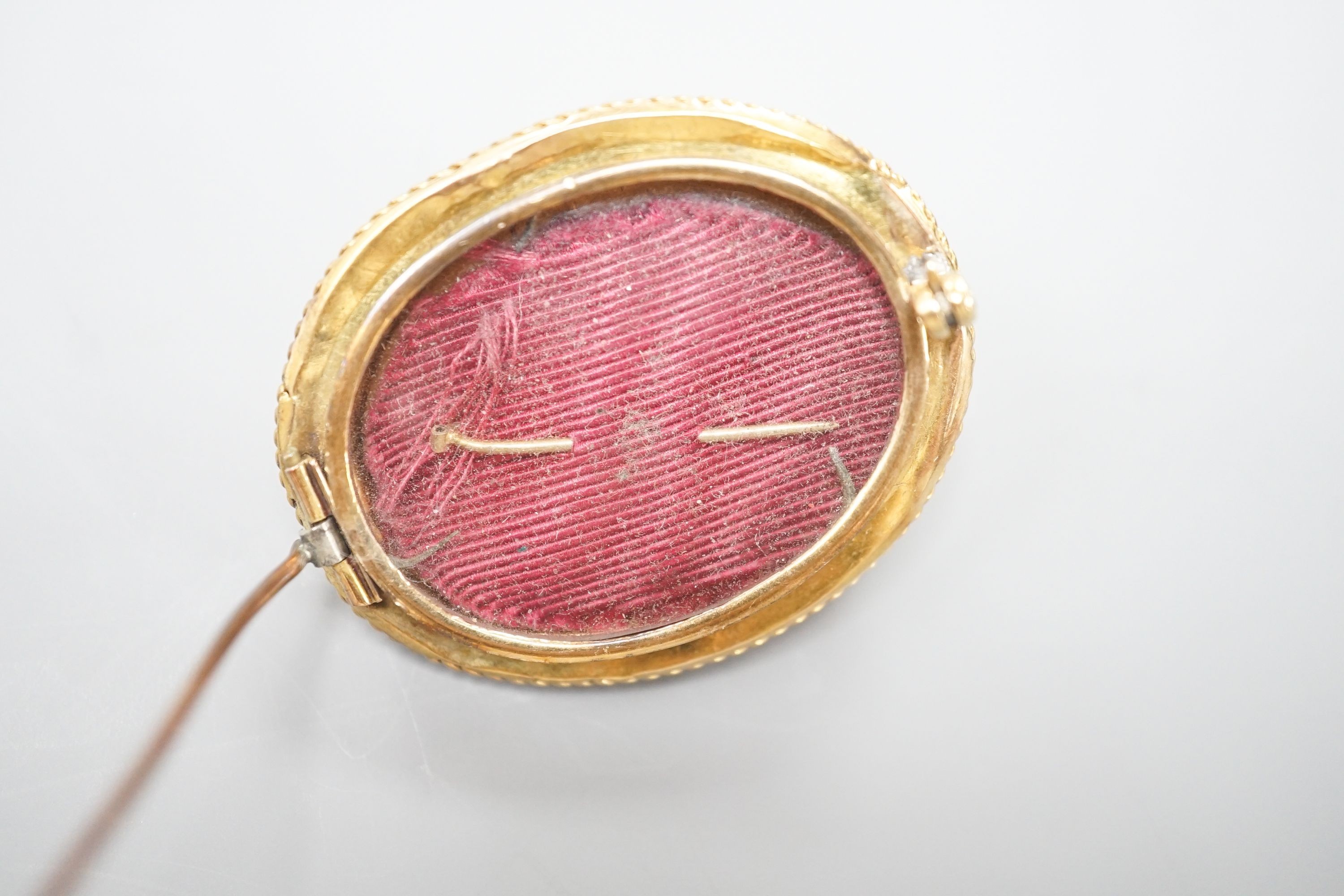 A Victorian yellow metal, ruby? and seed pearl set oval brooch, with glazed back, 43mm, gross weight 18.7 grams.